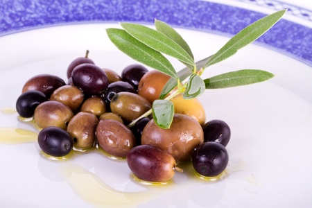 Detail view of some olives on a plate, with leafs from the tree.の写真素材