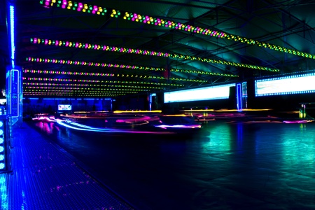 View of a amusement park bumper cars in motion at night.のeditorial素材