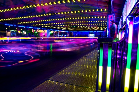 View of a amusement park bumper cars in motion at night.のeditorial素材