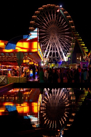 View of a amusement park ferris wheel in motion at night.のeditorial素材