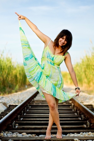 View of a beautiful girl with a spring dress on a railway.の写真素材