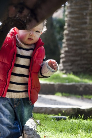 View of a young child peeking behind a urban bench.の写真素材