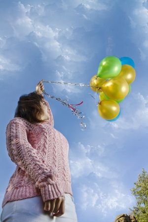 View of a beautiful girl with balloons on nature.の写真素材