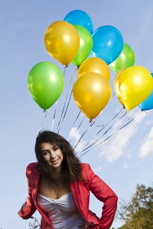 View of a beautiful girl with balloons on nature.の写真素材