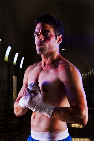 View of a wounded fighter with blood stains on a abandoned factory.の写真素材