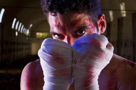 View of a wounded fighter with blood stains on a abandoned factory.の写真素材