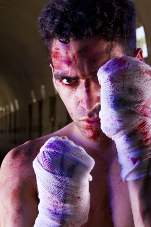 View of a wounded fighter with blood stains on a abandoned factory.の写真素材