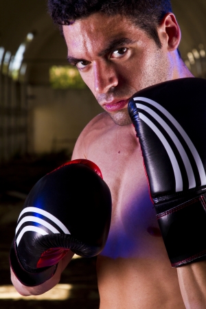 View of a fit fighter with boxing gloves on a abandoned factory.の写真素材