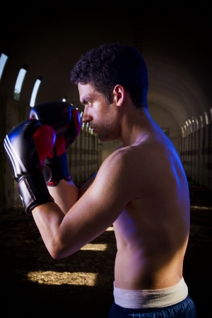View of a fit fighter with boxing gloves on a abandoned factory.の写真素材