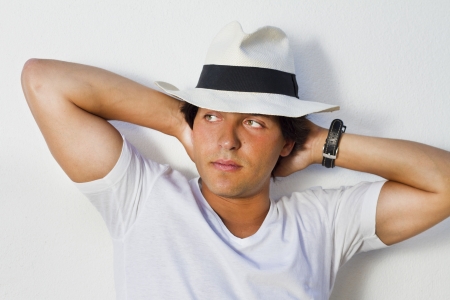 View of a handsome man with white shirt and hat on a urban city.の写真素材