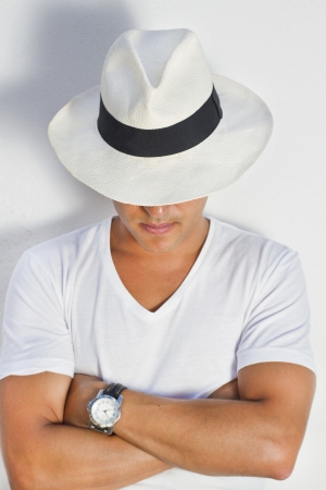 View of a handsome man with white shirt and hat on a urban city.の写真素材
