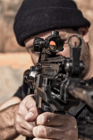 View of a man with a machine gun on a stone quarry.の写真素材