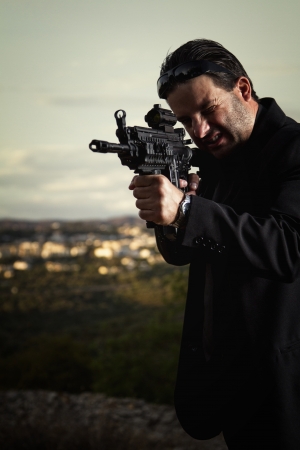 View of a contracted type killer agent wandering with a long jacket and machine gun.の写真素材