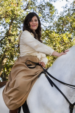 View of a beautiful girl in classic dress with a white horse on the countryside.の写真素材