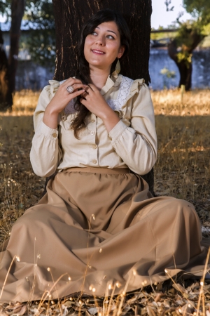 View of a beautiful girl in classic dress wandering on the countryside.の写真素材