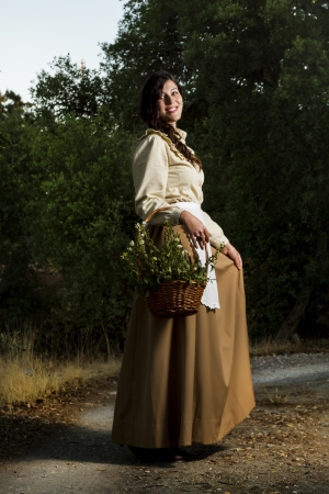 View of a beautiful girl in classic dress wandering on the countryside.の写真素材