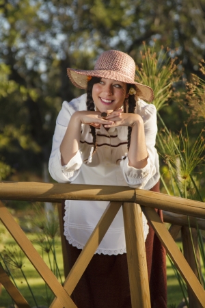 View of a beautiful girl in a classic dress in a countryside set.