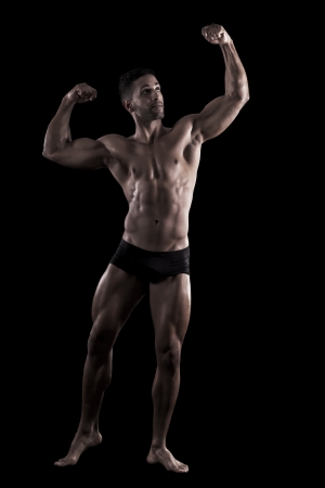 View of a muscled man on a black background in artistic, fitness and bodybuilding poses.の写真素材
