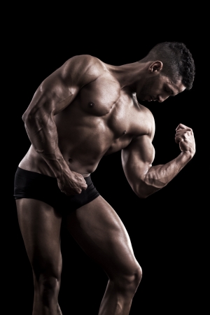 View of a muscled man on a black background in artistic, fitness and bodybuilding poses.の写真素材