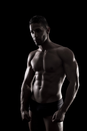 View of a muscled man on a black background in artistic, fitness and bodybuilding poses.の写真素材