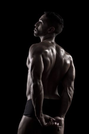 View of a muscled man on a black background in artistic, fitness and bodybuilding poses.の写真素材