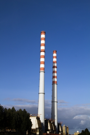 View of a industrial refinery factory with two tall fume towers.のeditorial素材