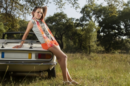 View of a beautiful woman posing on a white convertible car.の写真素材