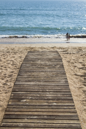 Close up view of a wood board walk in the beach pointing to the sea. の写真素材