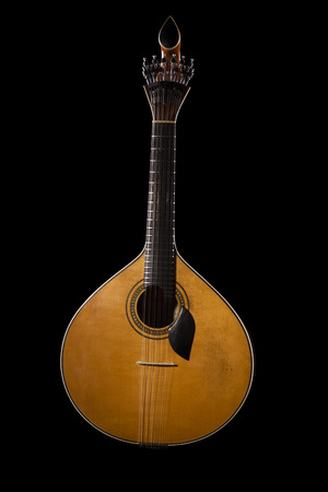 Close view of a traditional Portuguese guitar on a dark .の写真素材