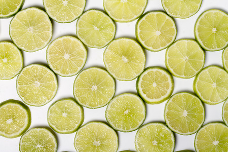 Close up view of a bunch of round slices of lime fruit isolated on a white .