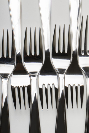 Close up view of kitchen table forks isolated on a white .の写真素材
