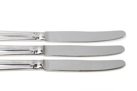 Close up view of kitchen table knifes isolated on a white background.