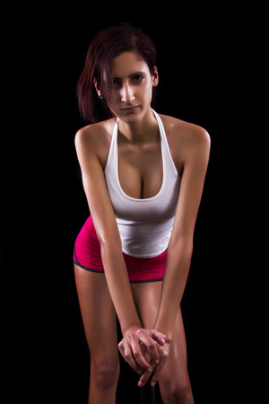Beautiful young girl with a tennis racquet on a black background.の写真素材