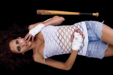 Fearful young street fighter girl on a black background.の写真素材