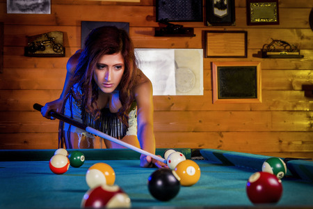 Close view of a beautiful cowgirl on a snooker club. 