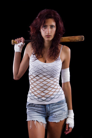 Fearful young street fighter girl on a black background.の写真素材