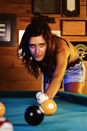 Close view of a beautiful cowgirl on a snooker club. 
