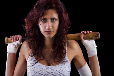 Fearful young street fighter girl on a black background.の写真素材