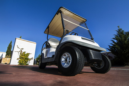Close up view of a white golf cart parked on the road.の写真素材
