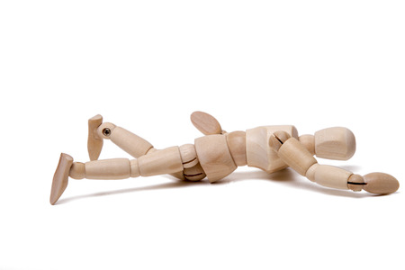 Close up view of a wooden dummy falling isolated on a white background.の写真素材