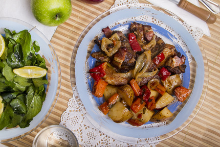 Close up view of oven baked meat with potatoes, and watercress salad.の写真素材