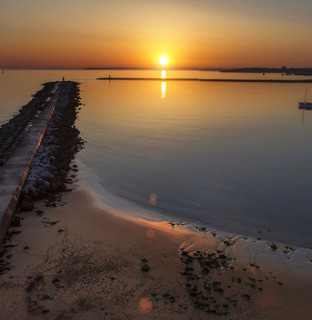 Dreamy view of a tide breaker pier at sunset.の写真素材