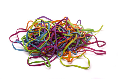 Close up view of a unordered pile of colorful elastic rubber bands isolated on a white background.の写真素材