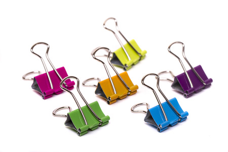 Close up view of several colorful office binder clips isolated on a white background.の写真素材