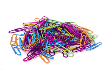 Close up view of a pile of several colorful office paper clips isolated on a white background.の写真素材