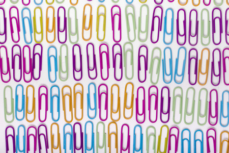 Close up view of vertical lines of colorful office paper clips isolated on a white background.の写真素材
