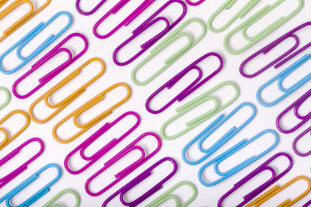 Close up view of vertical lines of colorful office paper clips isolated on a white background.の写真素材