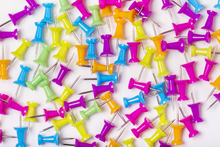 Colorful and scattered push pins on a white background.の写真素材