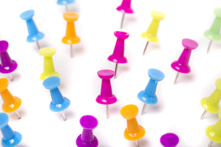 View of several scattered pinned colorful push pins isolated on a white background.の写真素材