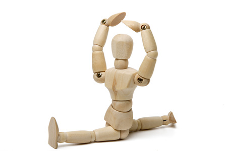 Close up view of a wooden dummy doing gym poses isolated on a white background.の写真素材